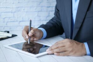 Man in suit using stylus on tablet for business work indoors